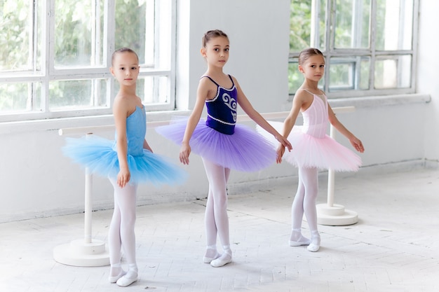 Drie kleine balletmeisjes in tutu en samen poseren