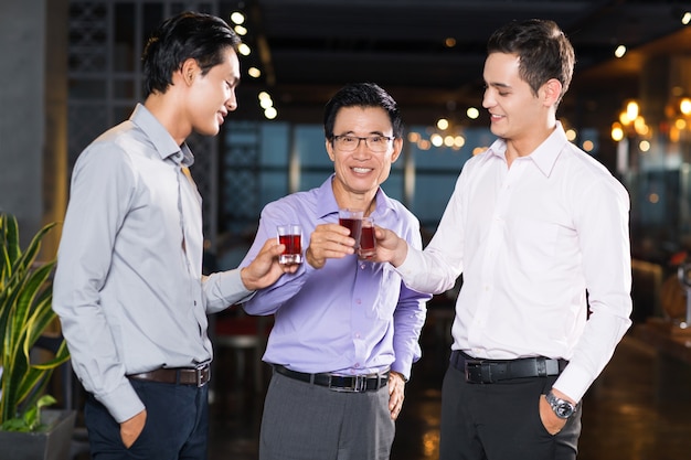 Drie lachende mannen roosteren in Bar