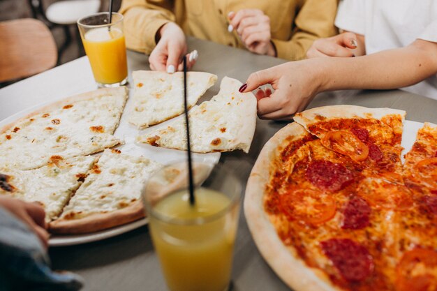 Drie meisjesvrienden die pizza hebben bij een bar