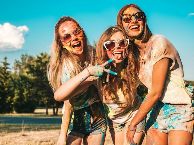 Drie mooie glimlachende meisjes poseren op Holi party