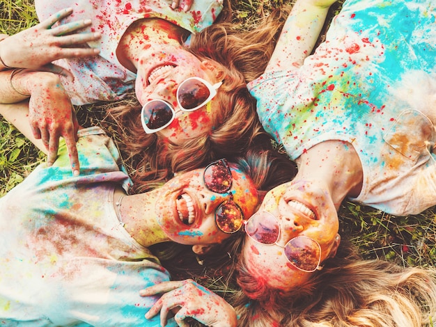 Drie mooie glimlachende meisjes poseren op holi party