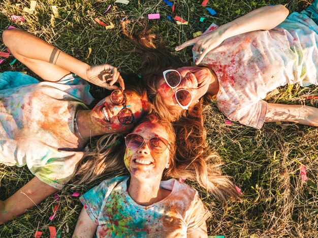 Drie mooie glimlachende meisjes poseren op Holi party