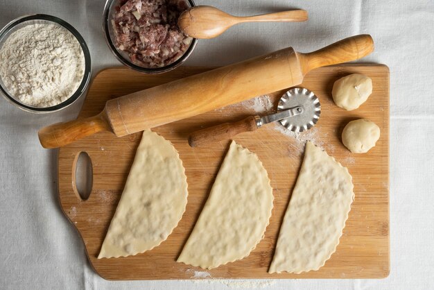 Drie ongekookt vlees gutabs op een houten bord. Azerbeidzjaanse nationale keuken.