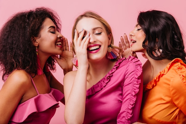 Drie opgewonden vrouwen die van gesprek genieten