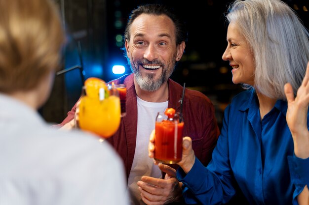 Drie oudere vrienden drinken in een restaurant.