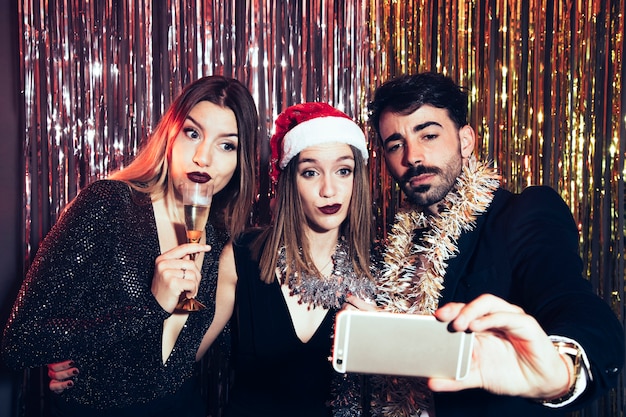 Drie personen nemen selfie op nieuwjaarspartij