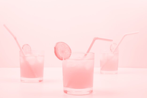 Drie roze cocktailglazen op gekleurde achtergrond