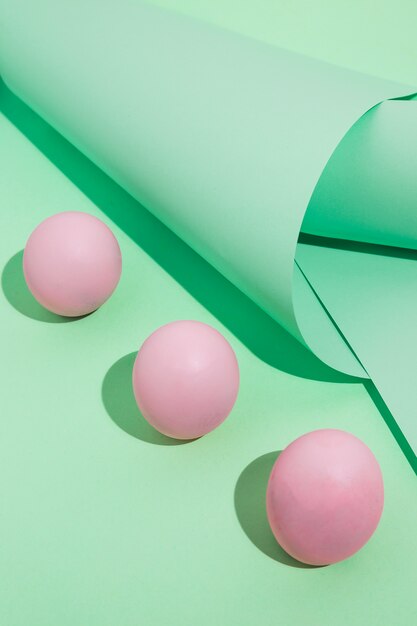 Drie roze paaseieren met groen gerold papier