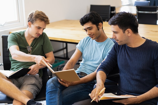 Drie serieuze medestudenten studeren, leerboeken lezen