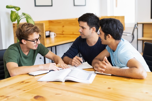 Drie serieuze studenten studeren, huiswerk maken