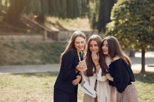 Drie studenten staan in een universiteitscampus