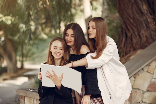 Drie studenten staan in een universiteitscampus