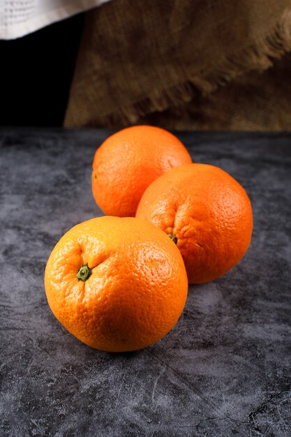 Drie verse sinaasappelen op een rij.