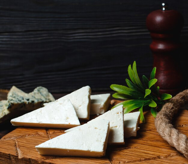 Driehoekige witte kaas op een houten bord