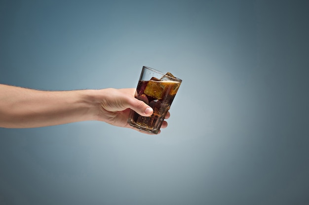 Drink cola in glas met hand