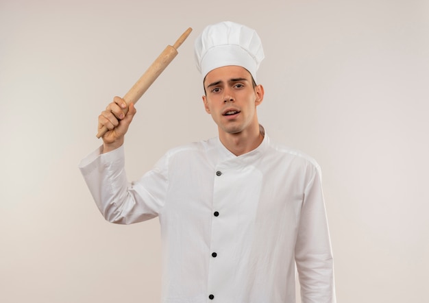 Droevige jonge mannelijke kok die de deegrol van de chef-kok eenvormige holding rond schouder draagt