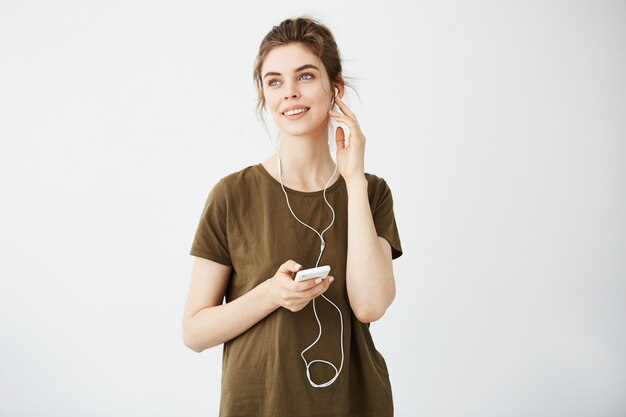 Gratis foto dromerige jonge mooie vrouw die luistert het luisteren muziek in hoofdtelefoons