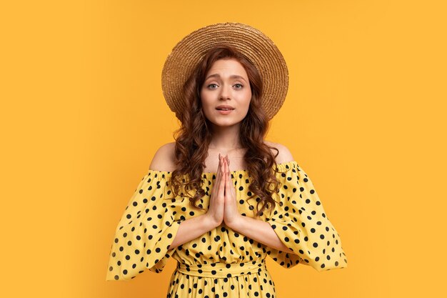 Dromerige roodharige vrouw poseren in gele jurk met mouwen op geel. zomerstemming.