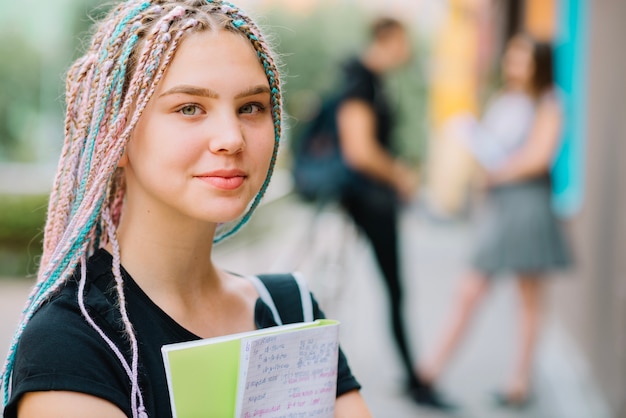 Dromerige tiener schoolmeisje met leerboek