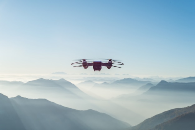 Drone vliegt over mistige en besneeuwde hoge heuvels en bergen