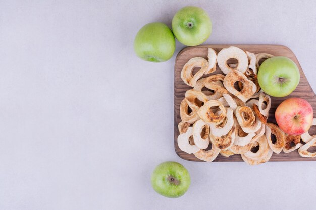 Droog appelschijfjes met hele appels in een houten schaal