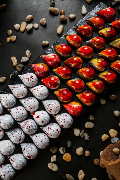 Drop vorm chocolade op het bovenaanzicht van het bord rood geel witte seastones