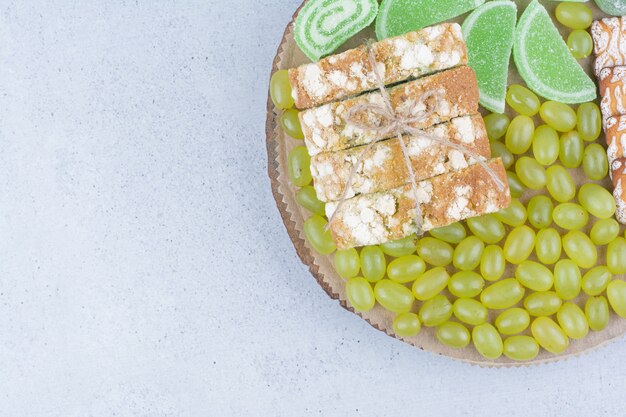 Druiven, cake en marmelade op een houten bord.