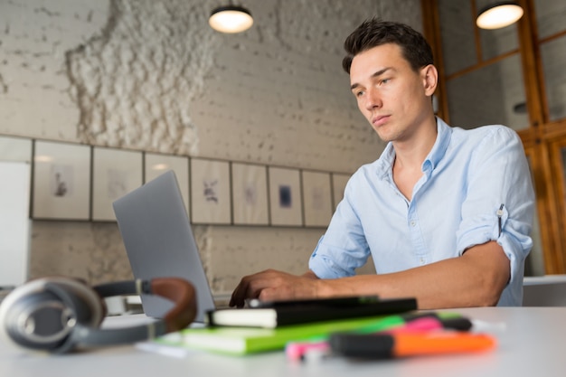 Drukke online externe werknemer jonge zelfverzekerde man aan het werk op laptop