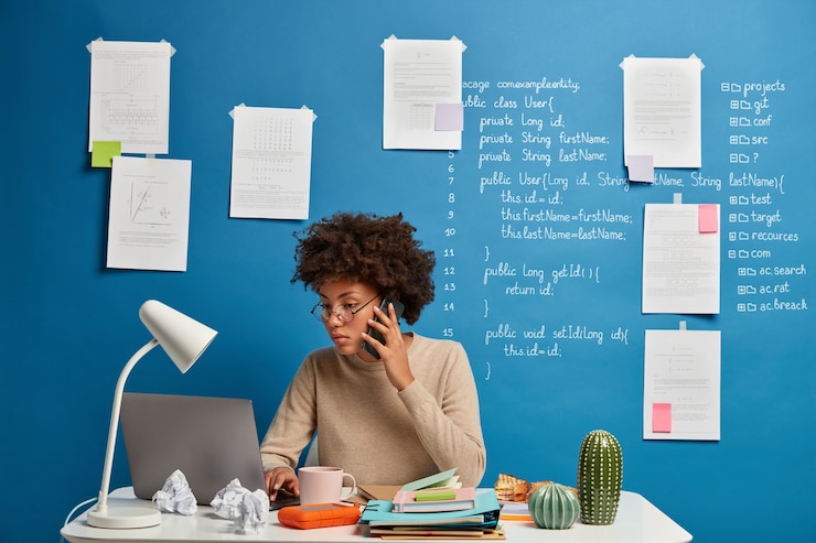 Gratis Foto drukke vrouwelijke secretaris typen tekst op laptopcomputer, stuurt feedback, bladert website, geconcentreerd in scherm, maakt telefoontje.