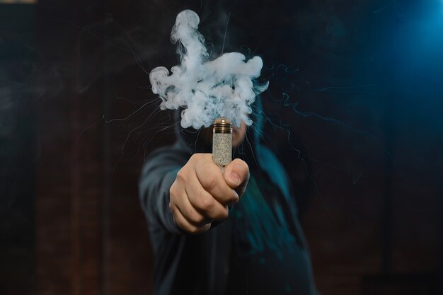 Druppelaar in één hand die een wolk van rook maakt