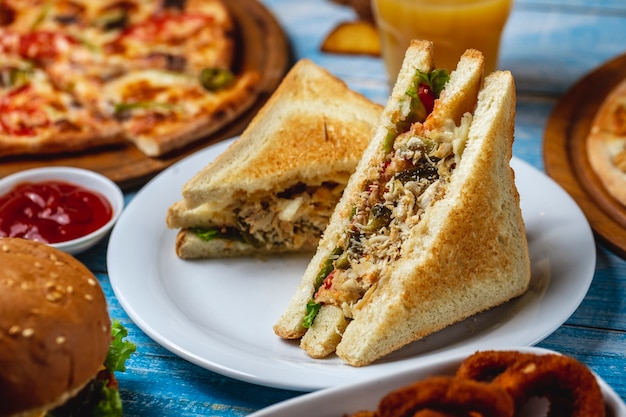 Dubbeldekker kippenborst sla kaas toast brood tomaat komkommer frietjes zijaanzicht