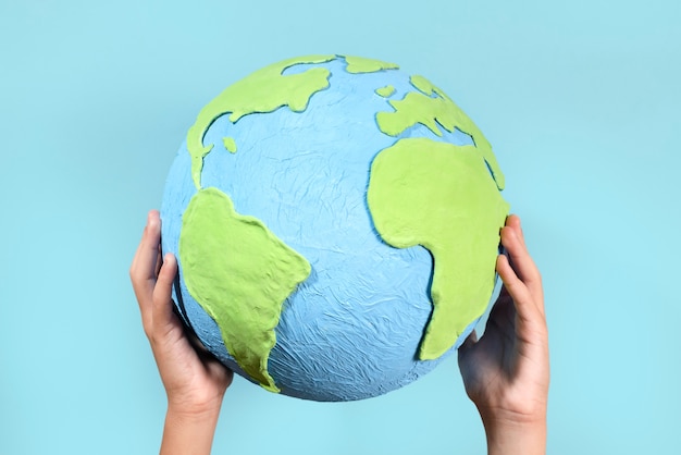 Gratis foto earth globe-vorm in papierstijl in handen