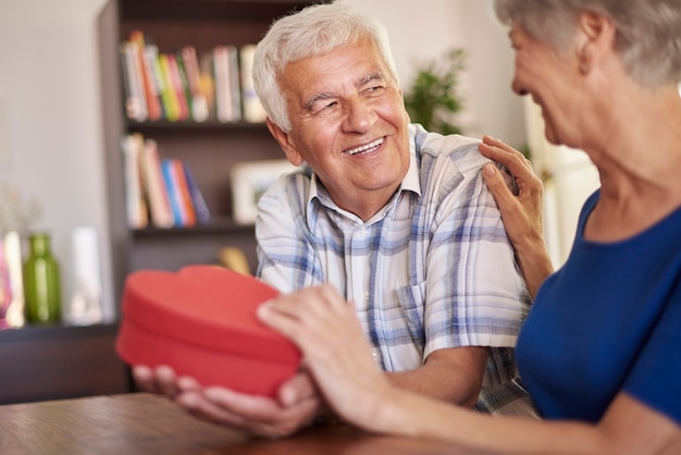 Echtgenoot die een hartvormig cadeau aan zijn vrouw geeft