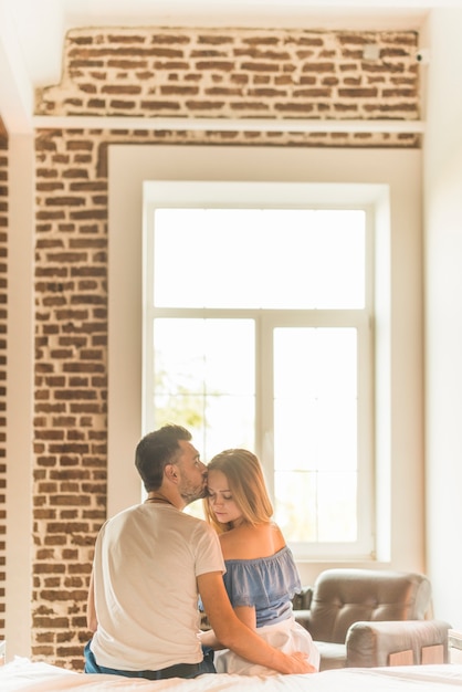 Echtgenoot die zijn vrouw op voorhoofd kust