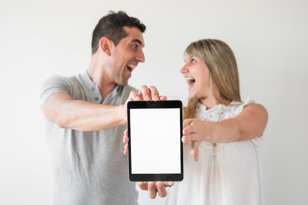 Gratis foto echtgenoot en vrouw die tablet op vadersdag tonen