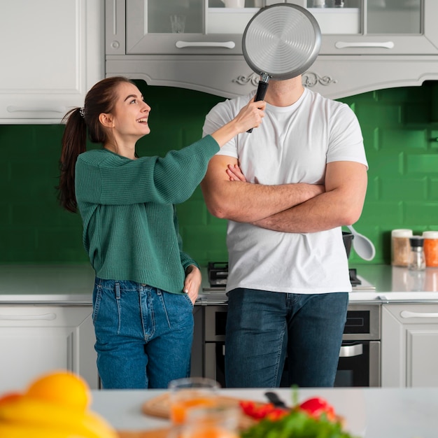 Gratis foto echtpaar met zeef in een groene keuken