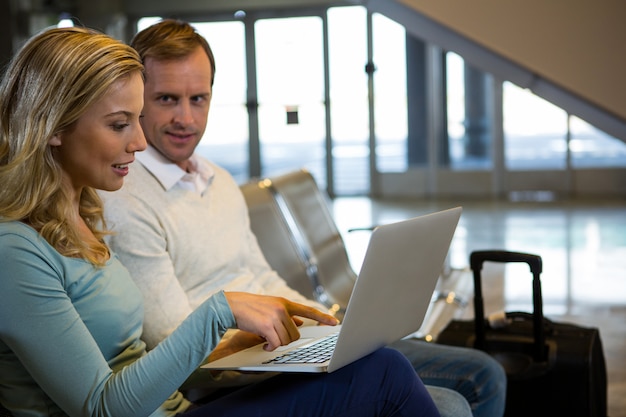 Echtpaar zit met laptop in de wachtruimte