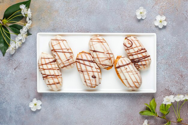 Eclairs of soesjes met zwarte chocolade en witte chocolade met vla erin, traditioneel Frans dessert.