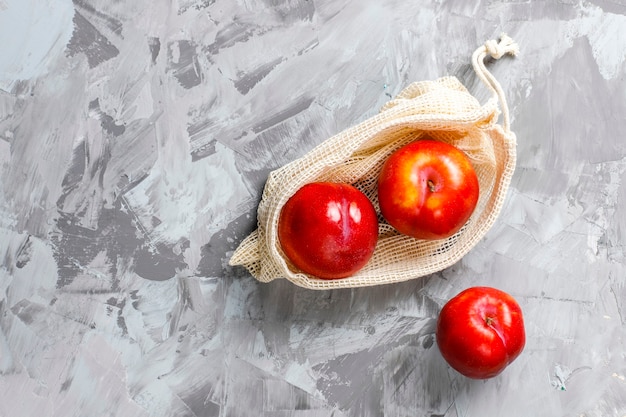 Eco-vriendelijke eenvoudige beige katoenen boodschappentassen voor het kopen van groenten en fruit met zomerfruit.