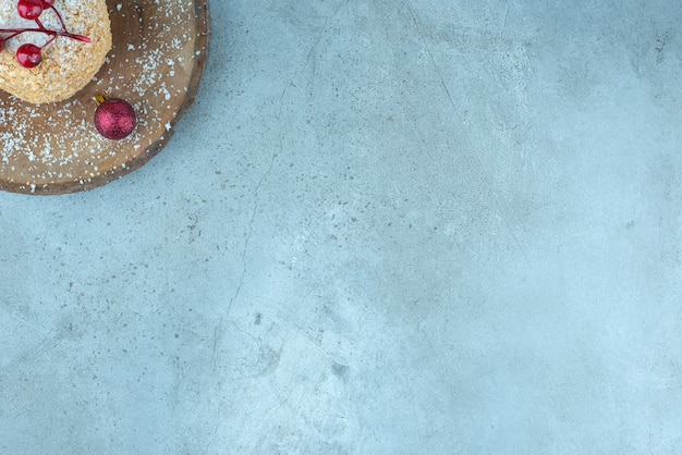 Eekhoorncake versierd met kerstversieringen op een bord op marmer.