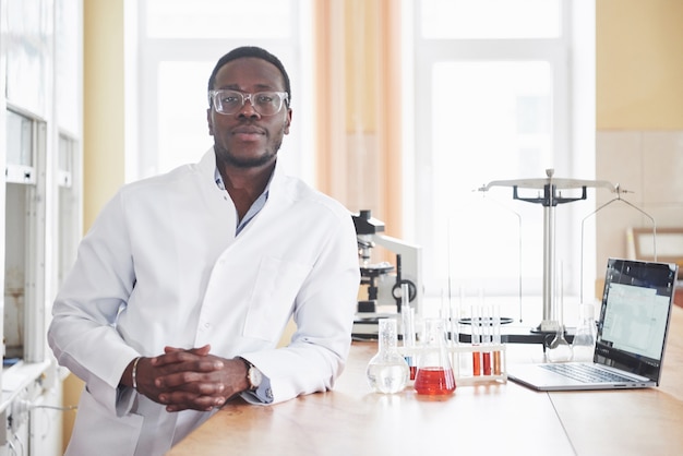 Een afro-amerikaanse werknemer werkt in een laboratorium en voert experimenten uit.