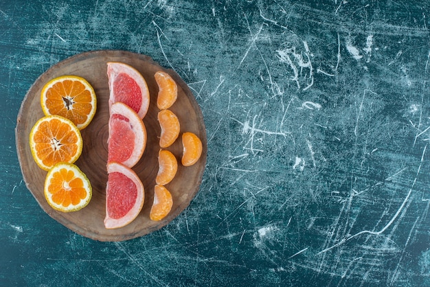 Een assortiment van citrusvruchtenplakken op een bord op de blauwe achtergrond. Hoge kwaliteit foto