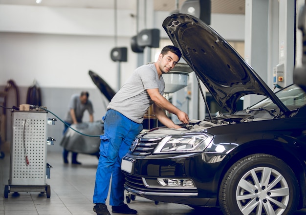 Een benchman die de motor van een auto bevestigt