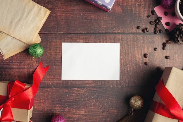 Een blanco wit papier en geschenkdozen op houten vloer