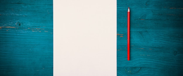 Een blanco wit vel en potlood om op een houten ondergrond te tekenen met ruimte om te kopiëren