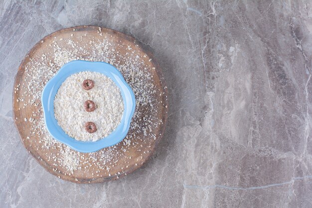 Een blauw bord gezonde havermoutpap met chocoladegranenringen.