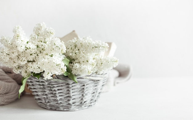 Een boeket witte lila bloemen in een decoratieve mand