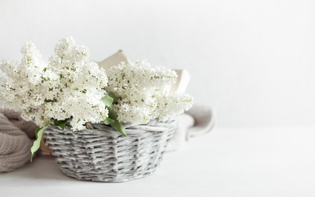 Een boeket witte lila bloemen in een decoratieve mand