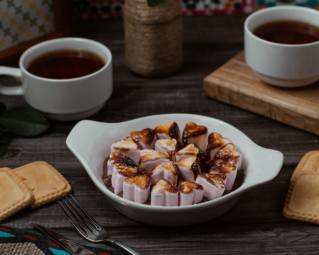 Gratis foto een bord met hartvormige vanille choco koekjes, koekjes met kopjes thee