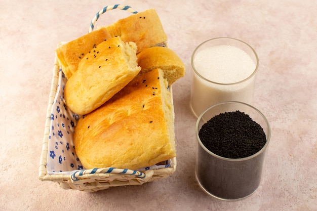 Gratis foto een bovenaanzicht gebakken brood warm lekker vers gesneden in broodtrommel alogn met zout en peper op roze